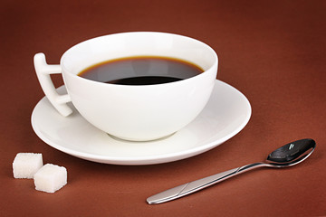 A cup of strong coffee on brown background