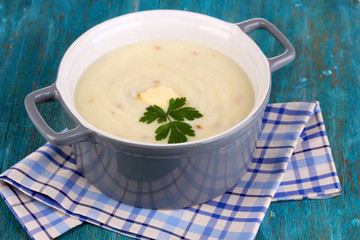 Mashed potatoes in saucepan on blue wooden table