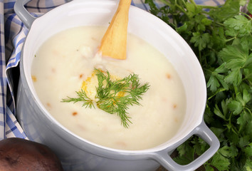 Mashed potatoes in saucepan with ingredients on wooden table