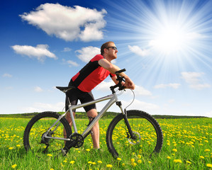 biker with the mountain bike in the dandelion field