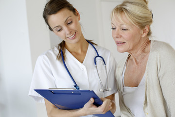 Nurse giving presciption to elderly woman