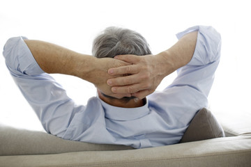Back view of old man relaxing in sofa