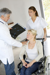 Obraz premium Doctor and nurse talking to patient in wheelchair