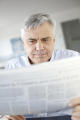 Senior businessman reading newspaper