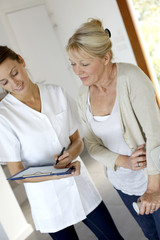 Nurse giving presciption to elderly woman