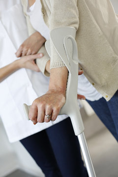 Closeup of old woman's hands leaning on crutches