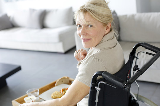 Senior woman in wheelchair holding lunch tray