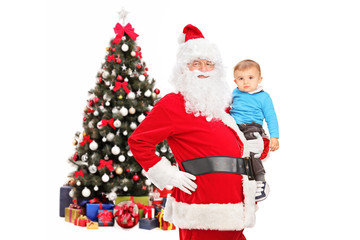 Santa Claus and child posing in front of a decorated christmas t