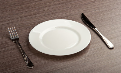 empty white plate with knife and fork