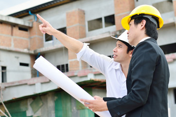 Two engineers are working on a construction area
