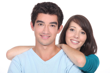 Young couple stood together against white background