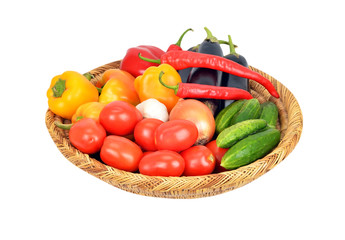 Vegetables in a wattled basket, isolated on white background