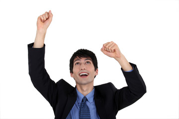Excited businessman raising his arms in the air