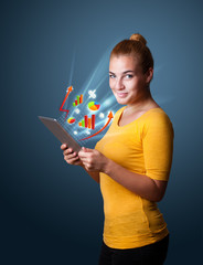 Young woman looking at modern tablet with abstract lights and va