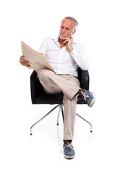 Casual senior man with newspaper, pondering