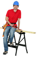 A carpenter seating on a workwrench.