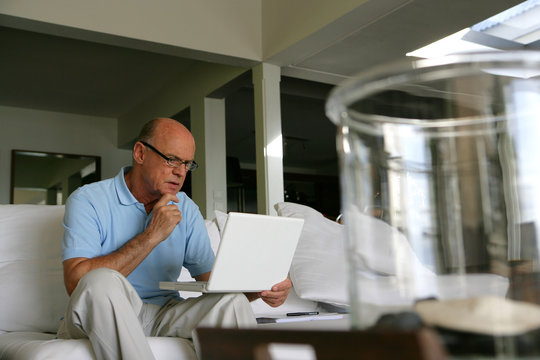 Bald man using his laptop at home