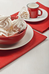 White meringues in a red bowl
