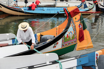 Portuguese sailor mooring traditional moliceiro boat in Aveiro,