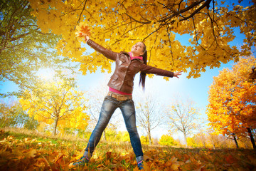 girl on a background of sky and autumn leafs