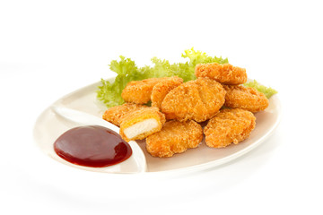 Plate of nuggets with dip sauce, one nugget cut