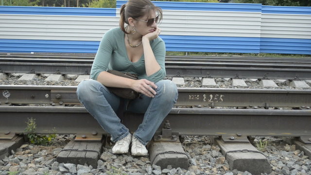 Tired young woman sitting on the rails
