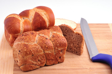Two loaves of bread and a knife on a board