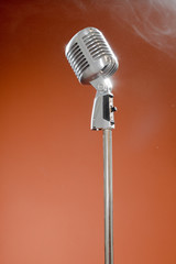 Vintage microphone against brown background.