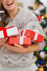 Closeup on Christmas present boxes holding by happy woman