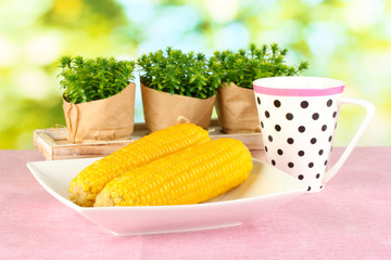 boiled corn on the pink table cloths on the background of