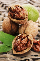 walnuts with green leaves, on  wicker background