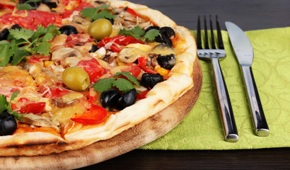 Delicious pizza close-up on wooden table on room background