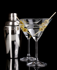 Martini glass with olives and shaker isolated on black