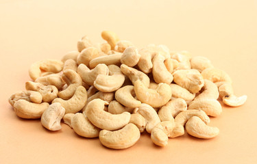 tasty cashews nuts, on beige background