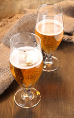 Glasses of beer on wooden table close-up