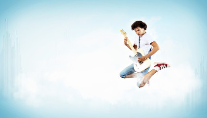 Fototapeta na wymiar Młody mężczyzna gra na gitarze elektro i skakanie