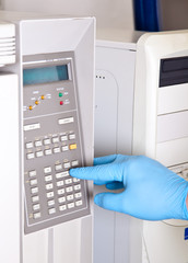 Scientist sets chromatograph oven temperature