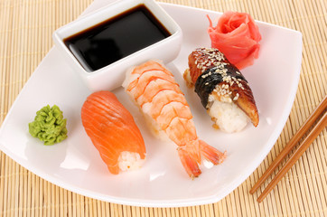 delicious sushi served on plate on bamboo mat