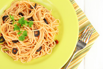 Italian spaghetti in plate on wooden table close-up