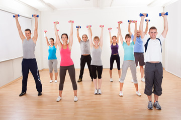 Aerobics class working out with dumbbells - obrazy, fototapety, plakaty