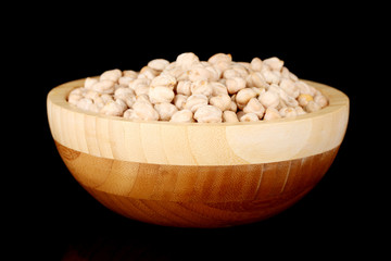 White chickpeas in  wooden bowl isolated on black