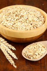 Oat flakes in wooden bowl on the table