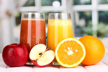 fresh fruit juices on wooden table, on window background