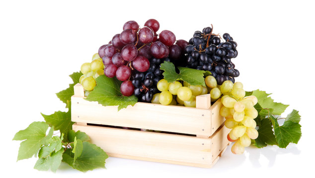 assortment of ripe sweet grapes in wooden crate, isolated