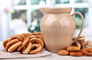 jar of milk, tasty bagels and spikelets on table