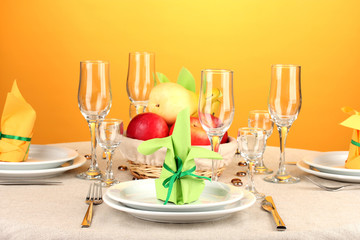 Table setting in green and yellow tones on color  background