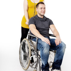 Obraz premium Man in wheelchair being pushed by woman