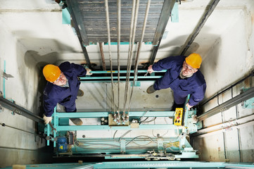 machinists adjusting lift in elevator hoistway © Kadmy