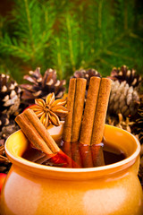 Mulled wine in brown jug with cinnamon and anise