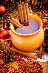 Mulled wine in brown jug with cinnamon and anise